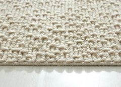 Close-up of Itsy Bitsy oatmeal-colored polyester wool and cotton fabric by India, showing soft texture and woven details.