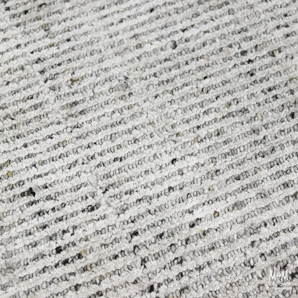 India Garcia Oyster rug made of wool and viscose, featuring a textured, earthy design with intricate patterns.