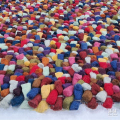 Colorful jelly bean-shaped wool and cotton multicolored toy from India, showcasing soft, vibrant textures and playful design.