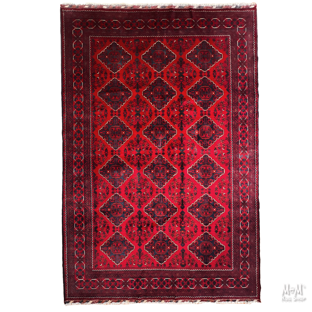 A traditional oriental rug with a deep red and dark maroon background, featuring a geometric diamond pattern and a decorative border.