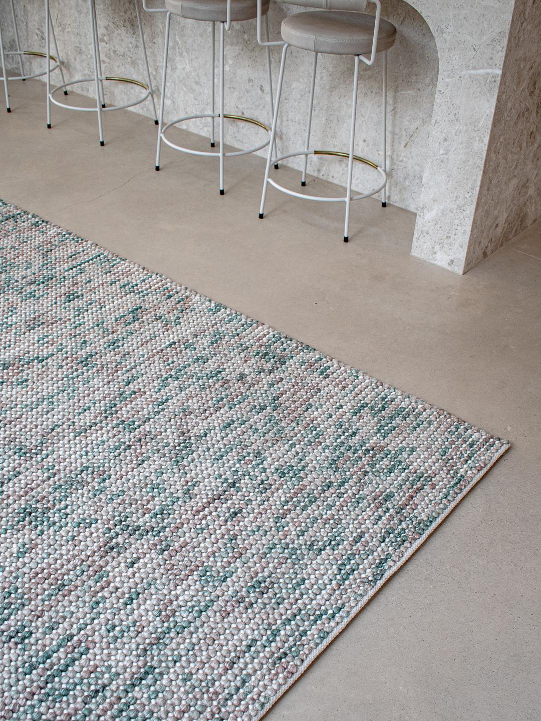 Close-up of Magic Oasis wool and viscose rug from India, showcasing intricate patterns and vibrant colors in a stylish interior setting.