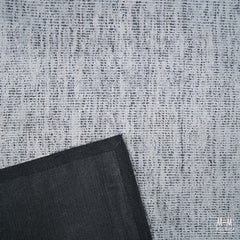 Close-up of a wool and viscose fabric named Toro Silver by India, showcasing its shiny, textured silver-gray surface.