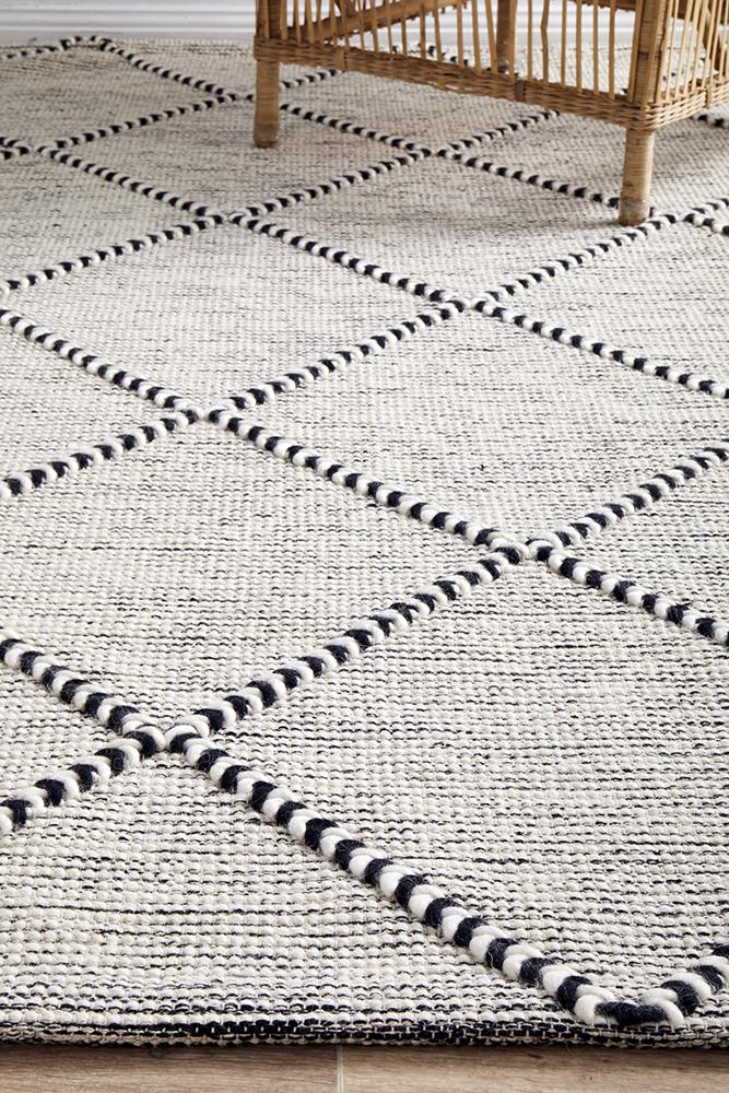 Pure wool Maison Jasmin blanket from India, showcasing soft, woven fabric with intricate patterns in natural tones.