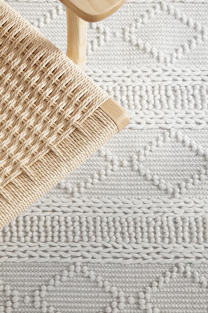 Pure wool blanket from Maison Zoe by India, soft and cozy with intricate woven patterns in natural tones.