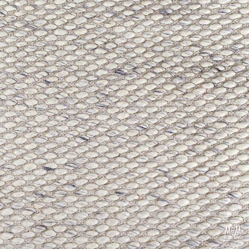 Beige Palmas Pure Wool Rug by India, showcasing a soft, textured wool surface with intricate patterns in a natural beige tone.