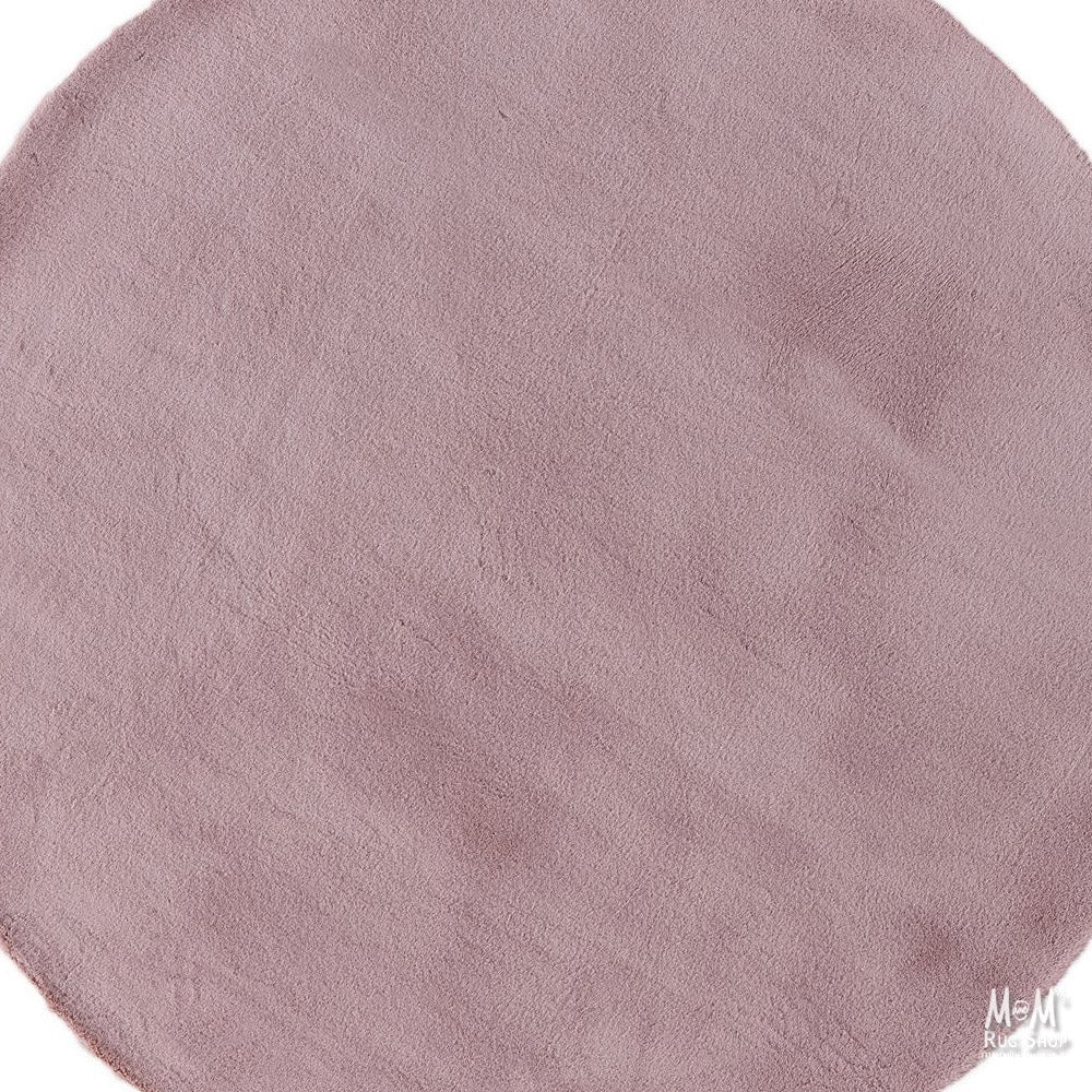 Dusty pink round pony rug made of supersoft polyester, featuring a plush, cozy texture perfect for home decor or children's rooms.