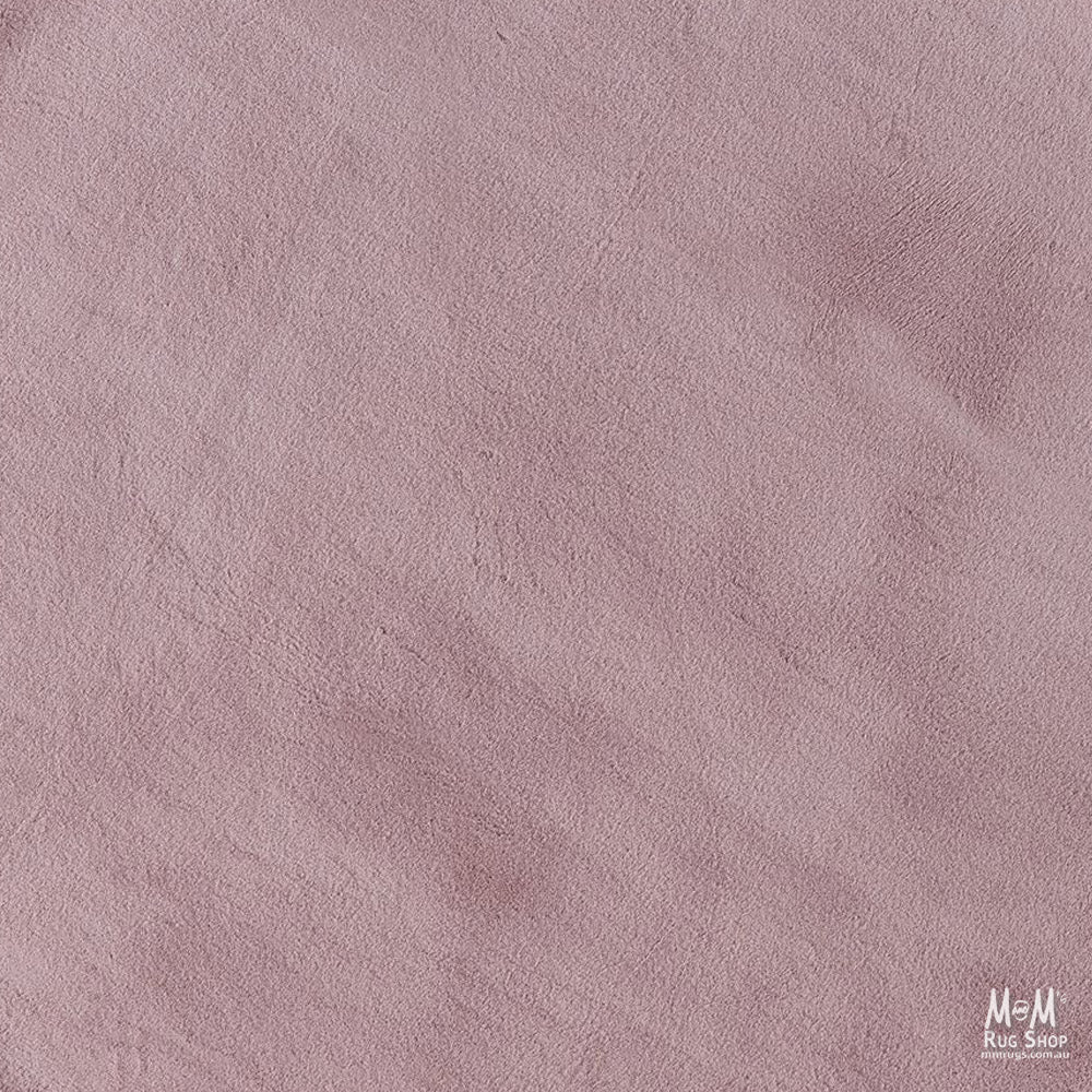 Dusty pink round pony rug made of supersoft polyester, featuring a plush, textured surface with a cozy, inviting appearance.
